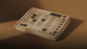 A wooden electronic game board with grid and knobs, featuring a digital display and buttons, set against a brown background.