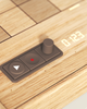 Close-up of a wooden electronic device with buttons, a joystick, and digital display reading "0123."