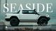 A photo of a white pickup truck with the text Seaside in the background