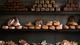 Different types of loafs of bread - rye bread, sourdough, and baguettes - stacked against a wall of a bakery