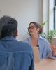 Two people in a bright, industrial office space working at a desk.