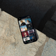 Smartphone on stone surface displaying a music app screen with artist thumbnails and options to explore genres.