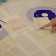 Workshop - close up of hands pointing to papers on a table