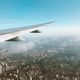 A plane wing and a city below taken from the window seat