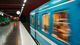 A photo of a Stockholm underground station, with a blue train passing