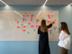 Two people standing in front of a white board with post-it notes