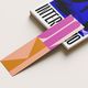 Abstract pink and orange bookmark on a book with partial text "INTER" and a blue cover design.
