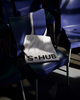 A white tote bag with the S•HUB logo, placed on a blue chair, symbolizing a bold and sustainable brand identity for environmentally conscious events.