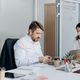 A man and a woman at a desk in an office collaborating