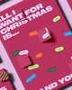 Red advent calendar with "All I Want for Christmas Is..." text and colorful, labeled flaps.