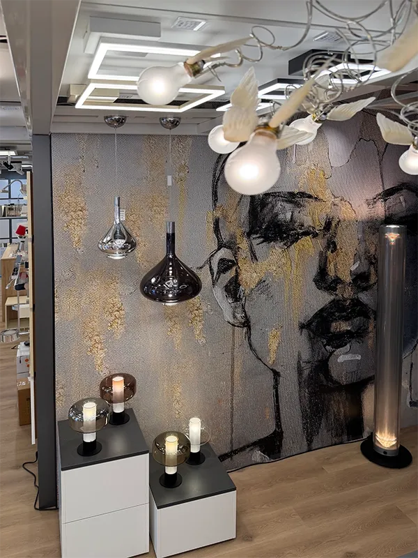 Lichthaus Melzer Showroom mit kunstvollem Wandbild, verschiedenen Decken- und Tischlampen, abstrakter Kunst, Holzboden und zeitgenössischem Design.