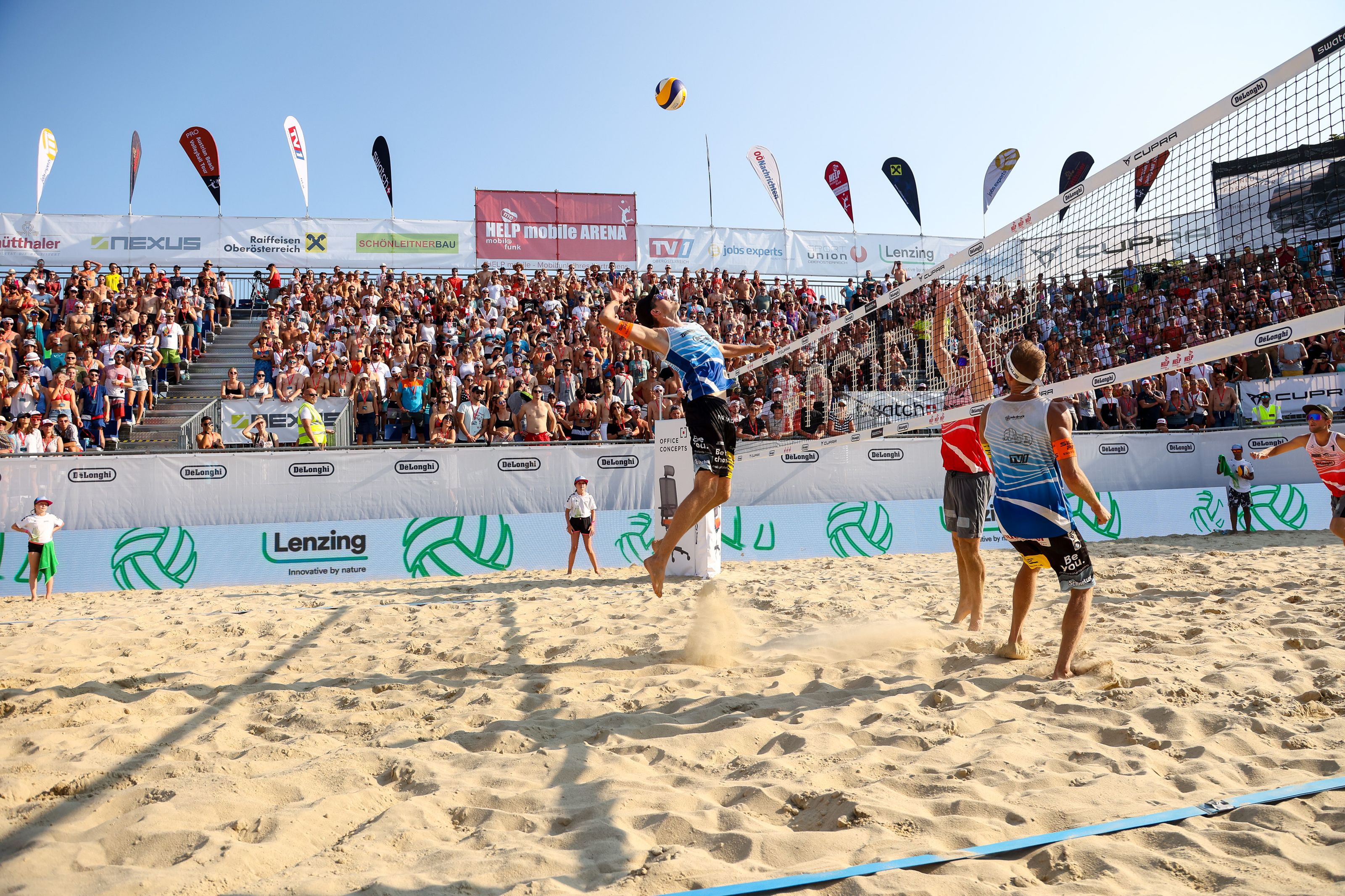 Men playing beach volleyball in center court