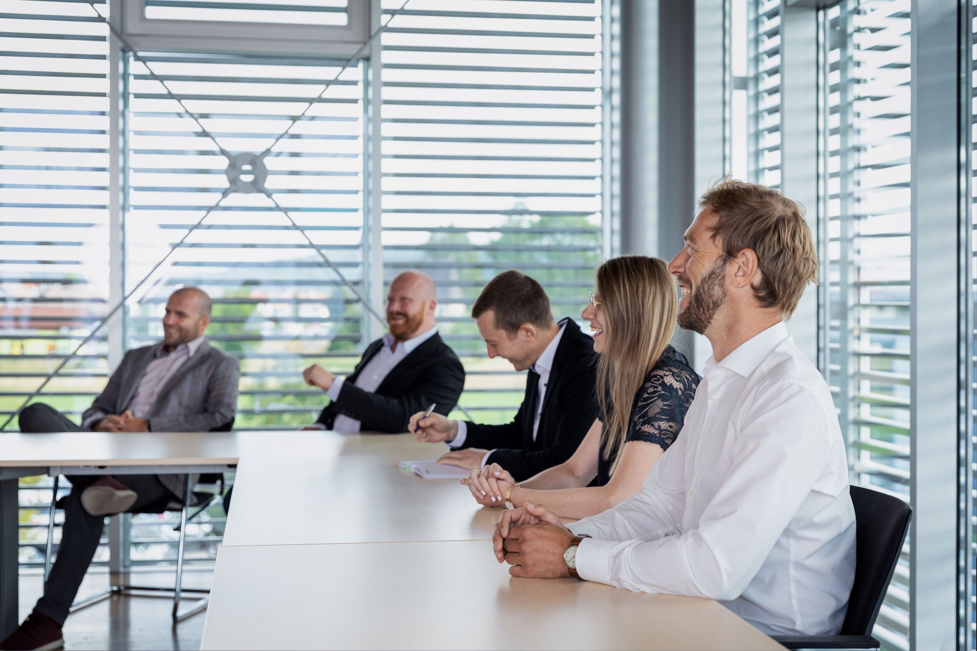 Mitarbeiter bei einer Besprechung sitzen am Tisch
