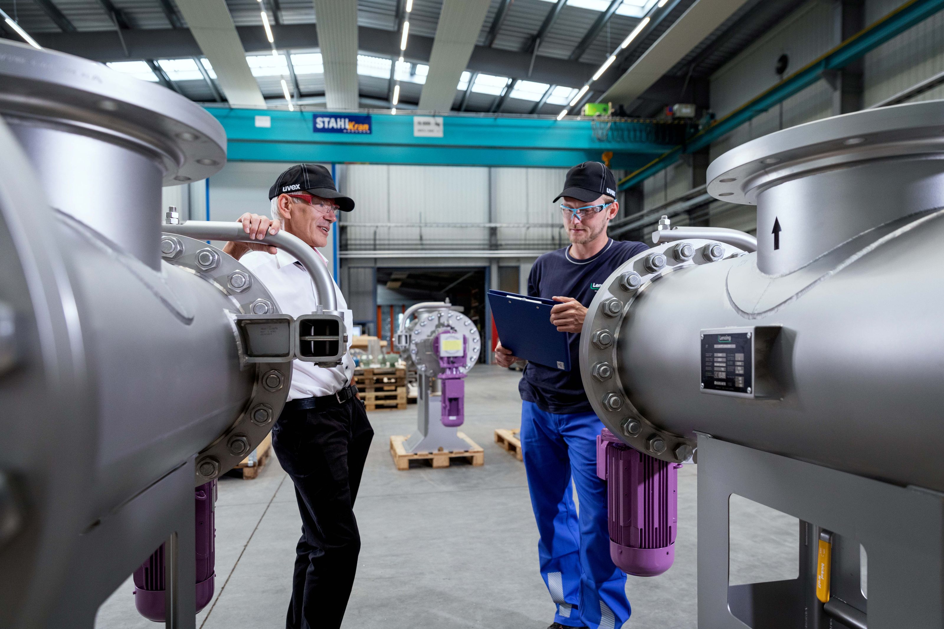 Zeigt zwei Mitarbeiter der Lenzing Filtration in der Filtermontagehalle