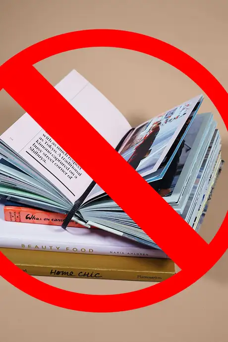A Pile of Books with a red sign on top of them