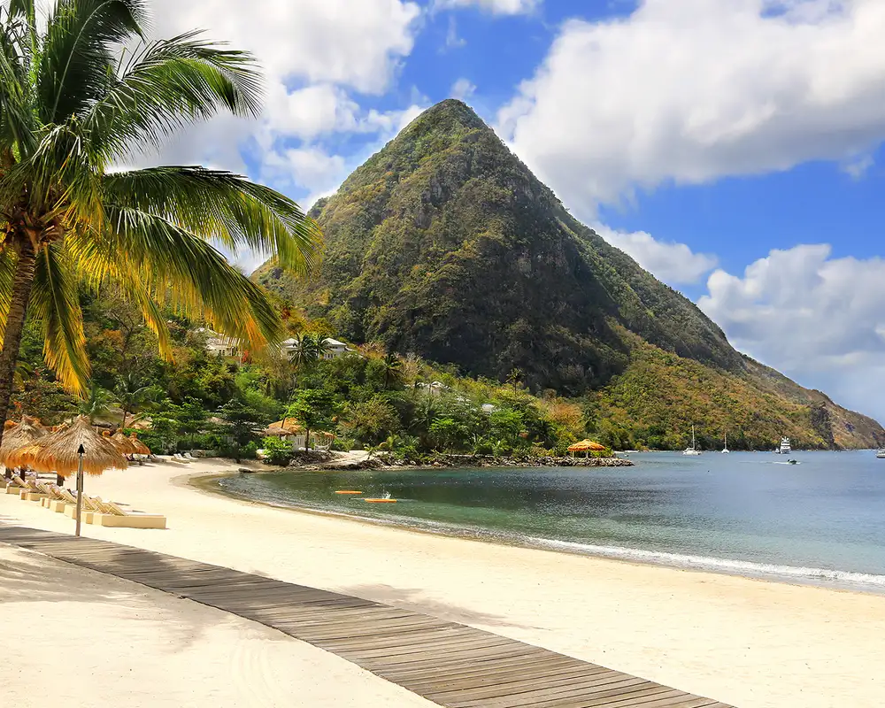 A beach in the Caribbean with a large mountain in the distance
