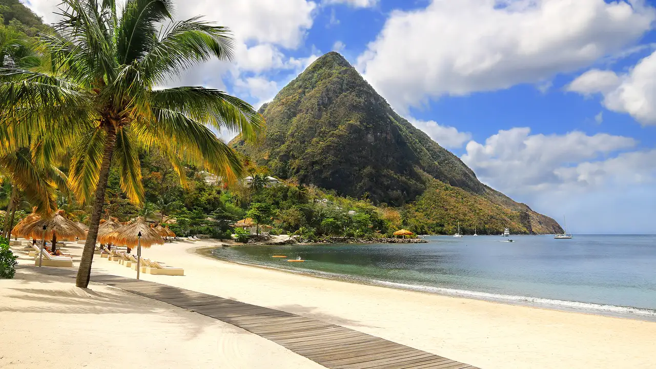 A beach in the Caribbean with a large mountain in the distance