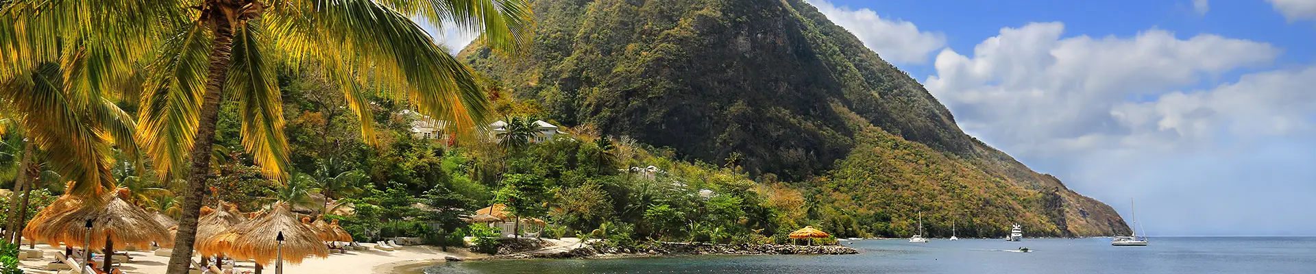 A beach in the Caribbean with a large mountain in the distance