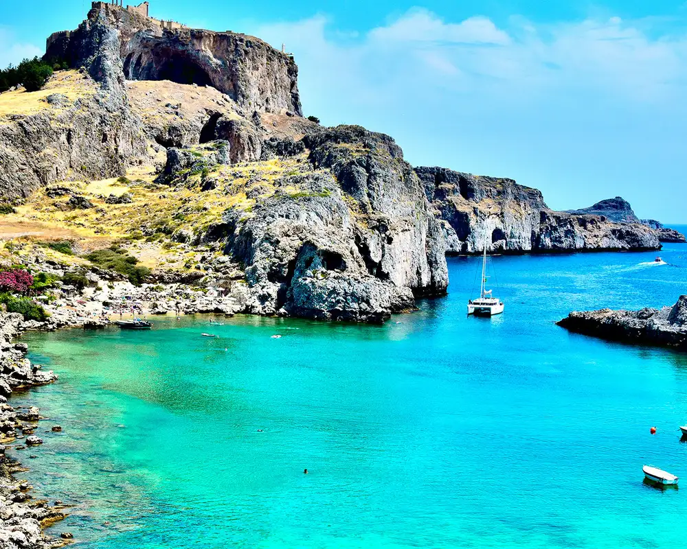 A bay in Rhodes, Greece that has vibrant blue water