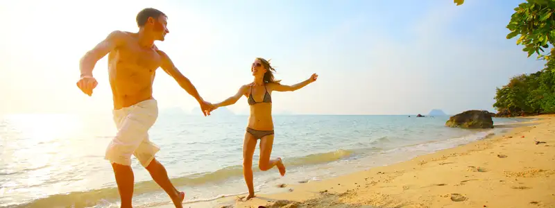 A Couple running down the shore of a Beach