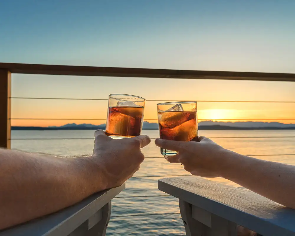 A Couple relaxing with drinks while looking over the ocean