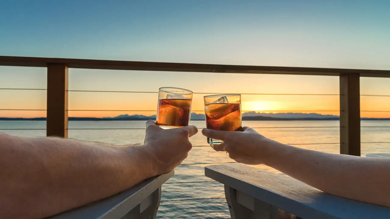 A Couple relaxing with drinks while looking over the ocean
