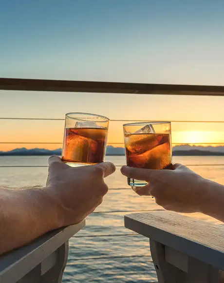 A Couple relaxing with drinks while looking over the ocean