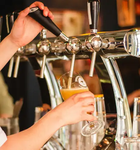 A Beer being poured by a bartender