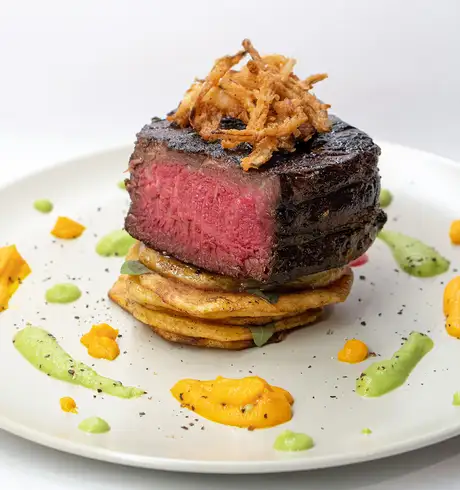 A steak prepared and plated in a fancy way