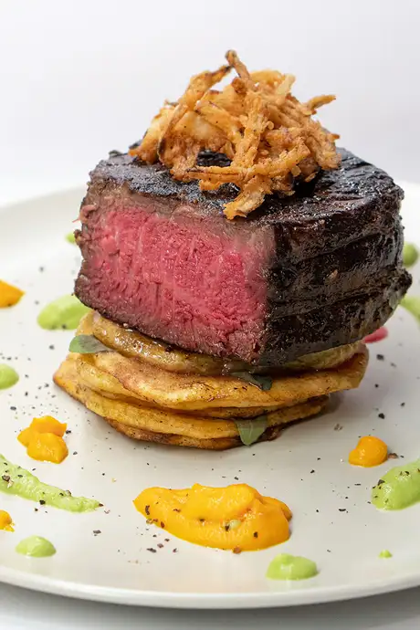 A steak prepared and plated in a fancy way