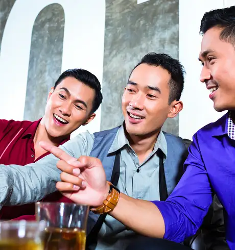 A Group of friends looking at a phone in a bar