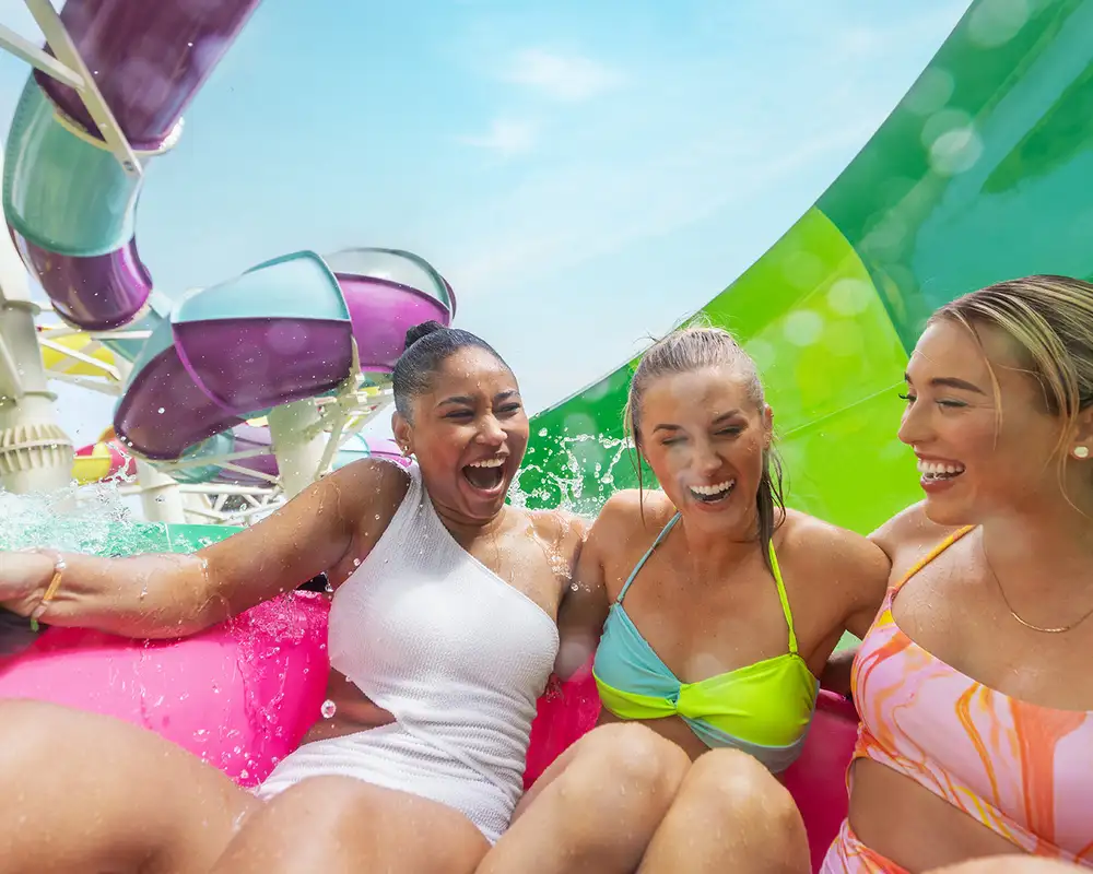 A group of friends going down a waterslide on CocoCay