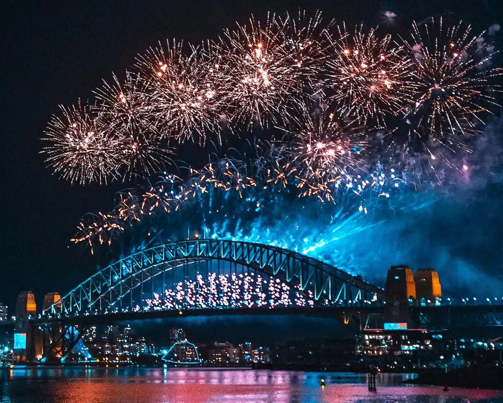 The Sydney Harbour bridge with fireworks going off above it