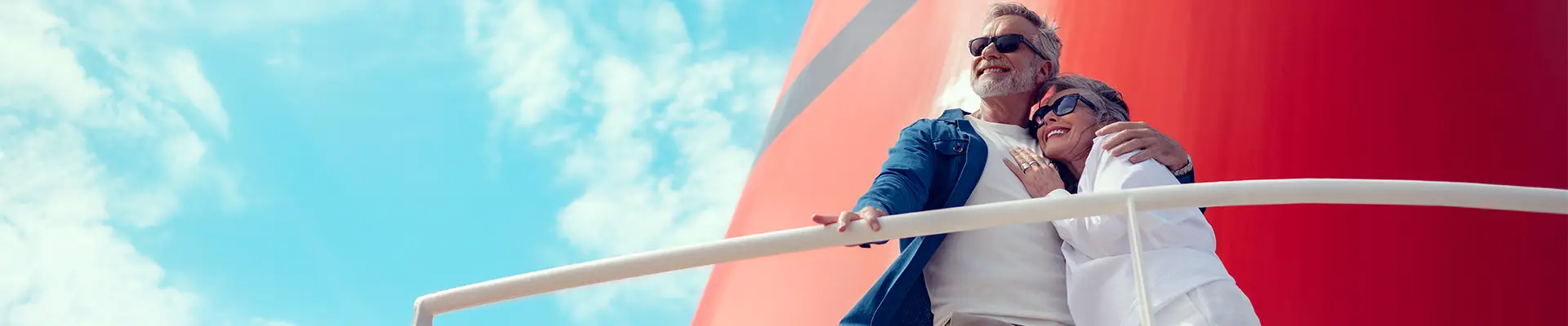 A couple leaning on a railing on a Cunard ship