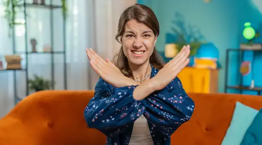A Woman Crossing her arms to make an X Shape