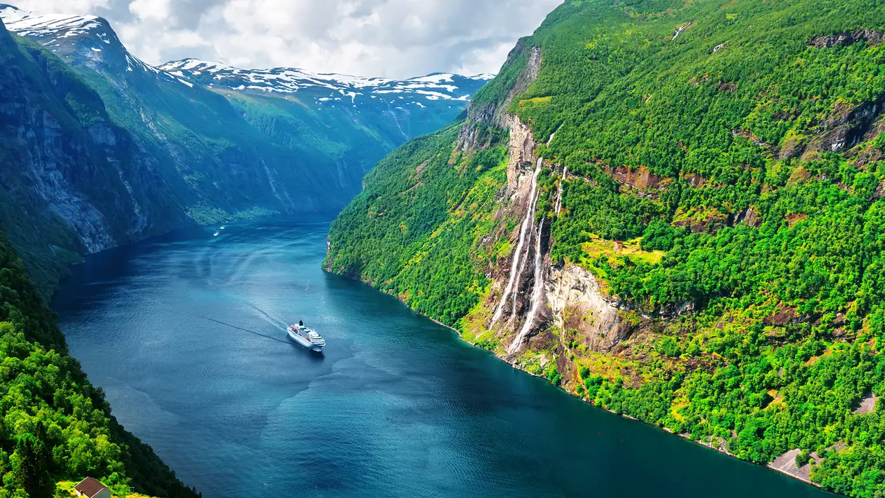 An image of a cruise ship sailing through a fjord