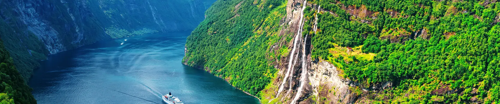 An image of a cruise ship sailing through a fjord