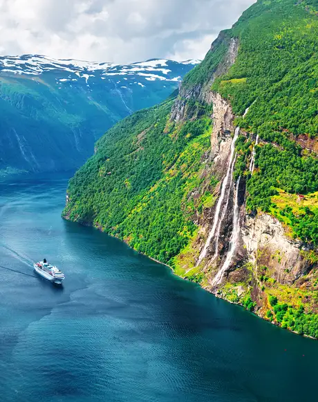 An image of a cruise ship sailing through a fjord