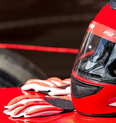 A Race helmet and gloves resting on a Race Car