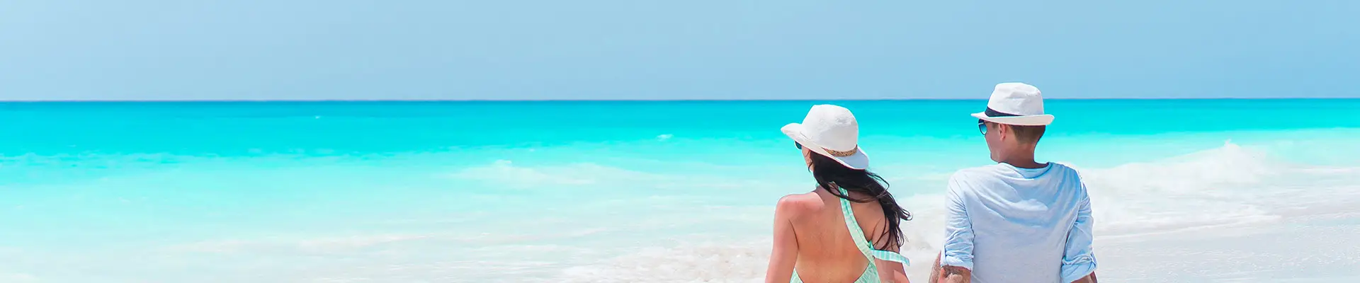 A couple sitting by the shore, relaxing on a Caribbean beach