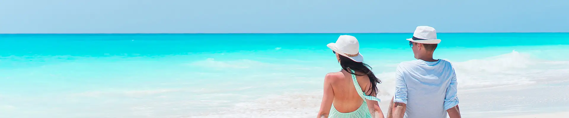 A couple sitting by the shore, relaxing on a Caribbean beach