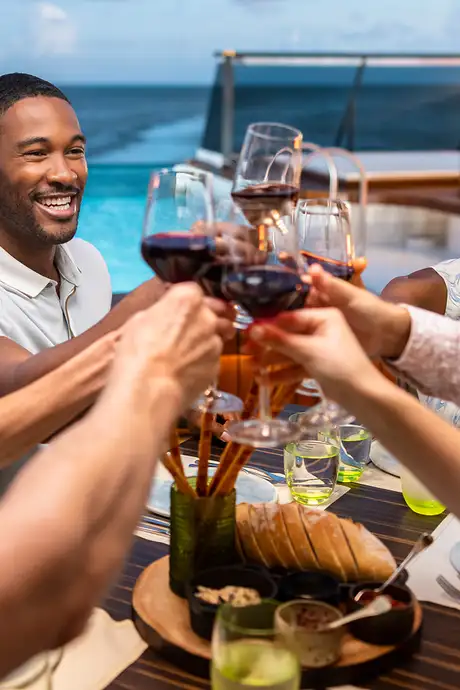Friends cheering drinks at Earth and Ocean on Seabourn Ships