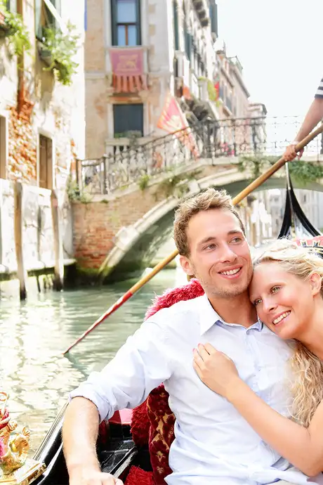 A couple on a gondola ride down a Venice canal