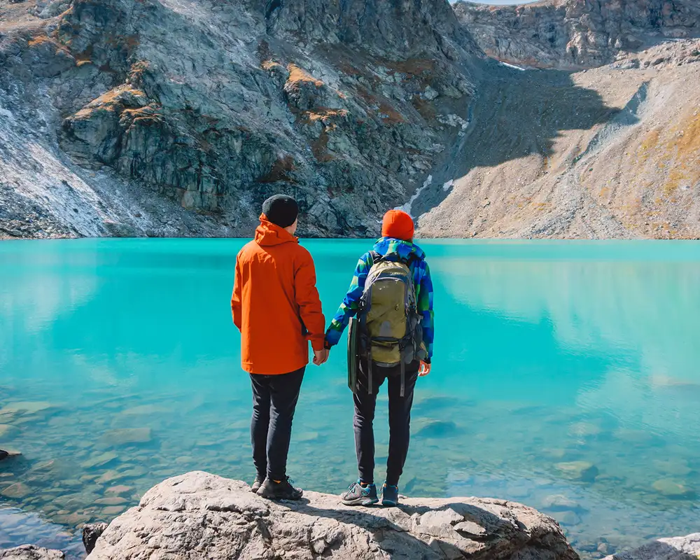A Couple holding hands and looking out over an Alaskan Lake