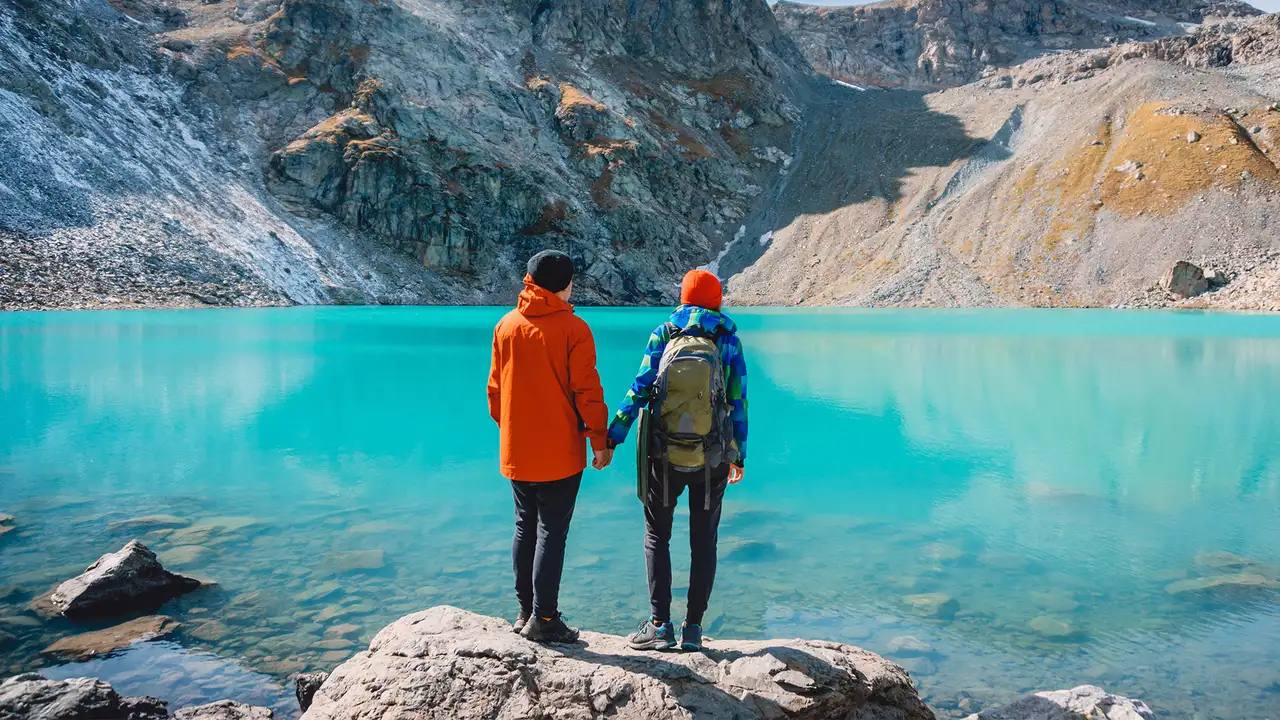 A Couple holding hands and looking out over an Alaskan Lake