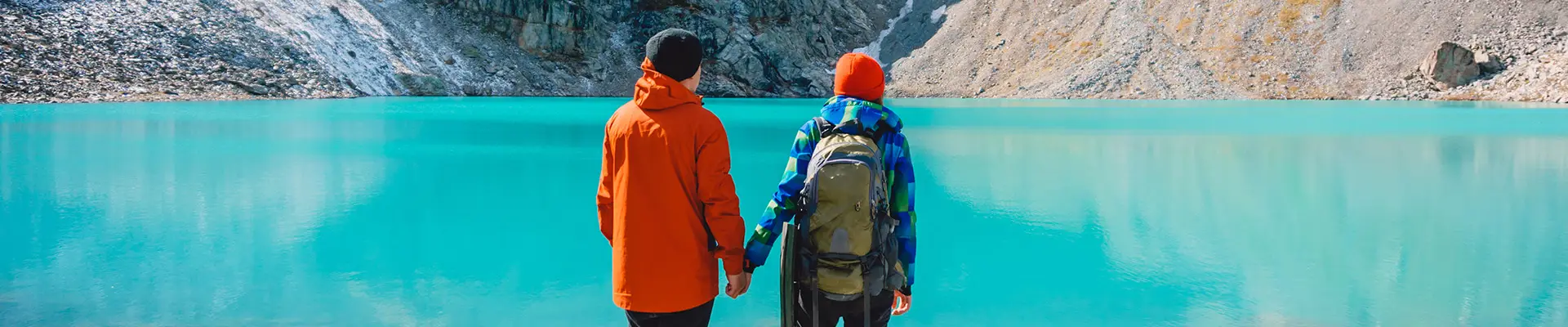A Couple holding hands and looking out over an Alaskan Lake
