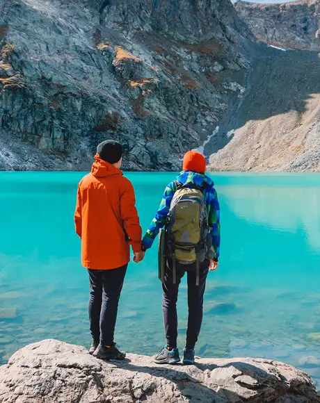 A Couple holding hands and looking out over an Alaskan Lake