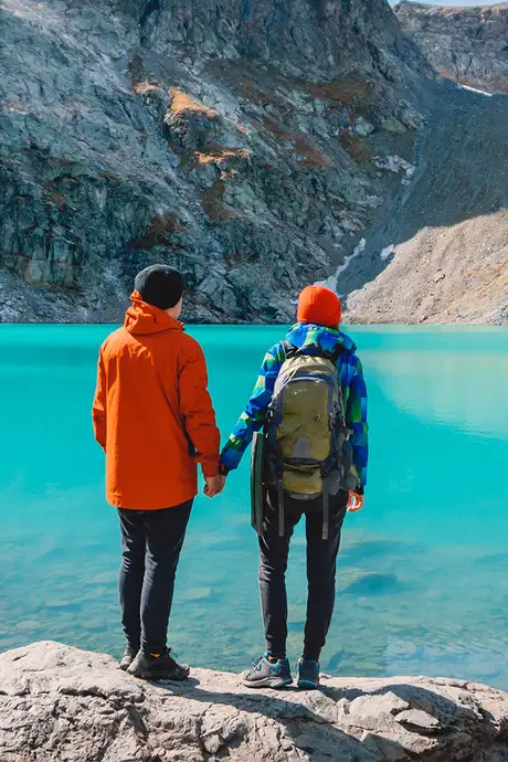 A Couple holding hands and looking out over an Alaskan Lake