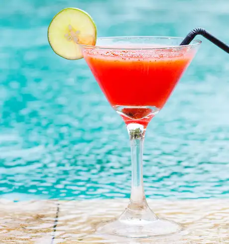 A Red Drink with a Cucumber garnish