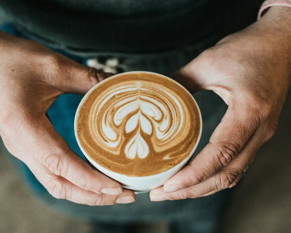 A person holding a cup of Coffee